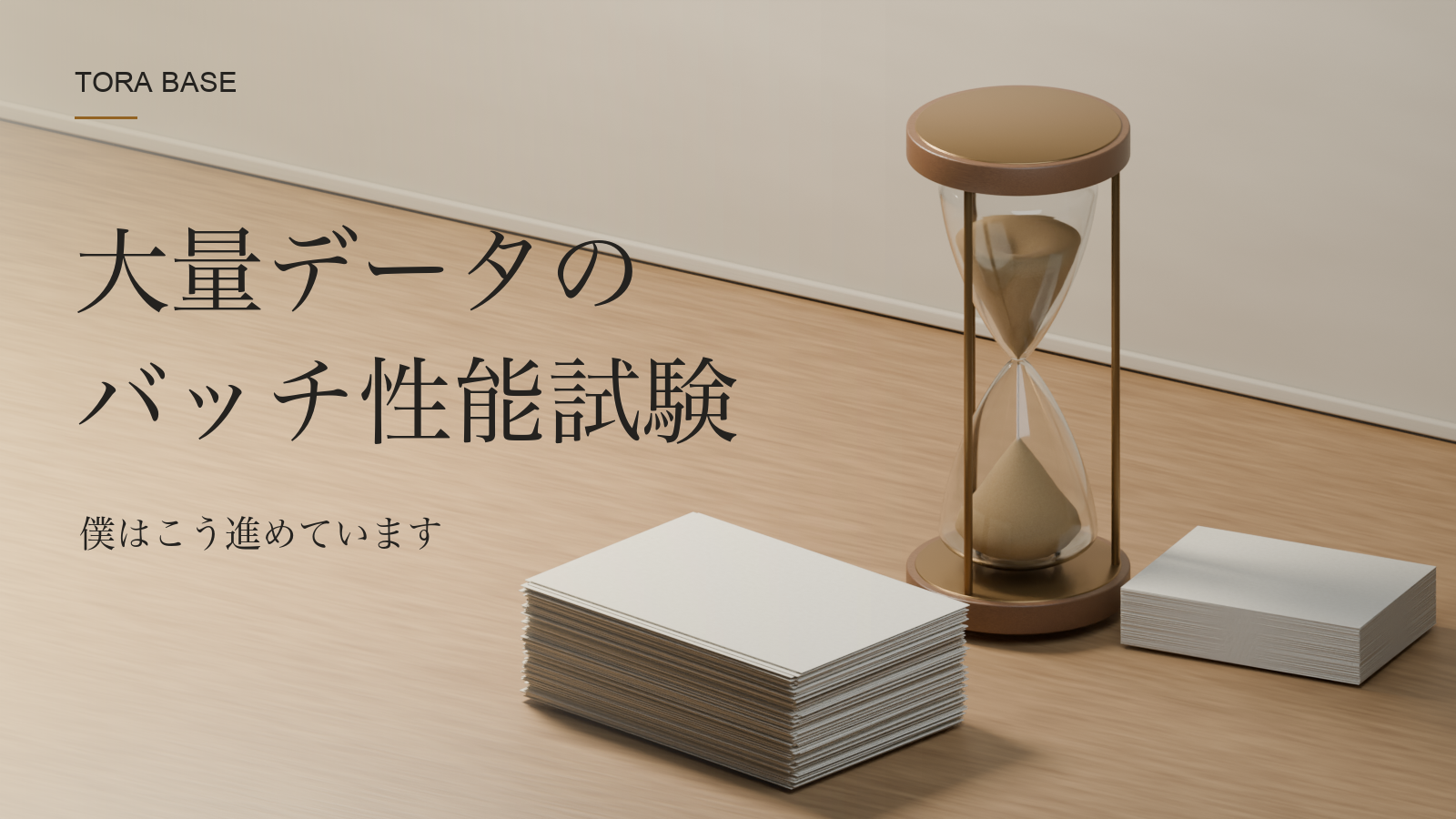 木目の見える机に置いた二つの白紙の束と砂時計を描いた写真調の概念CG。「大量データの バッチ性能試験」「僕はこう進めています」の見出し。
