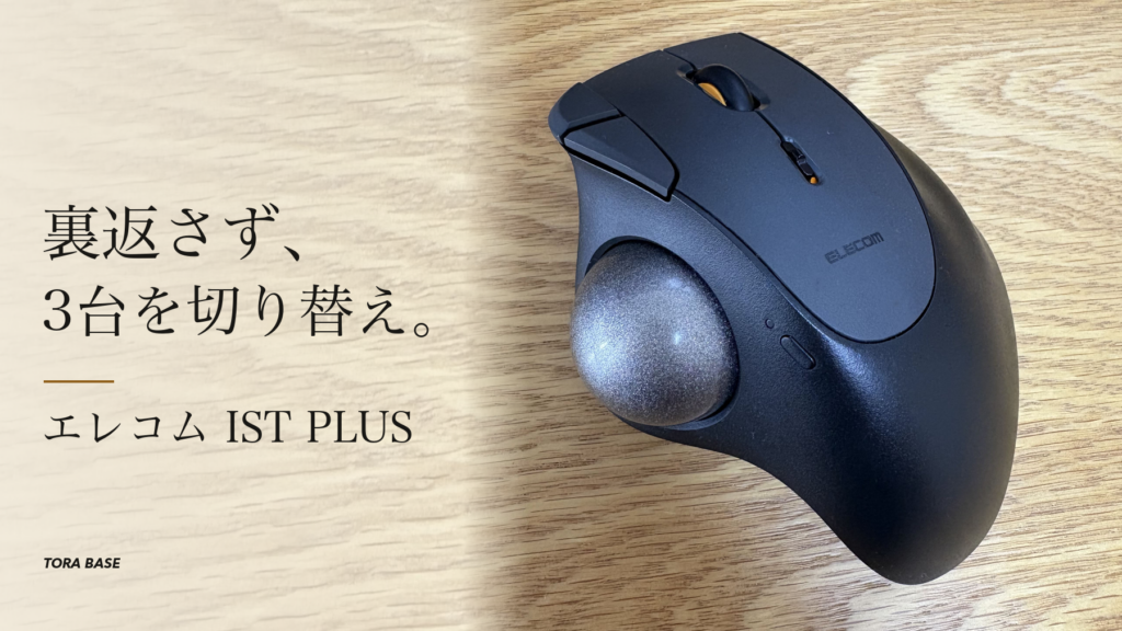 木目の上に置いたブラックのエレコム IST PLUS。親指ボール、ホイールと側面の操作部を大きく見せ、「裏返さず、3台を切り替え。」と紹介する表紙。